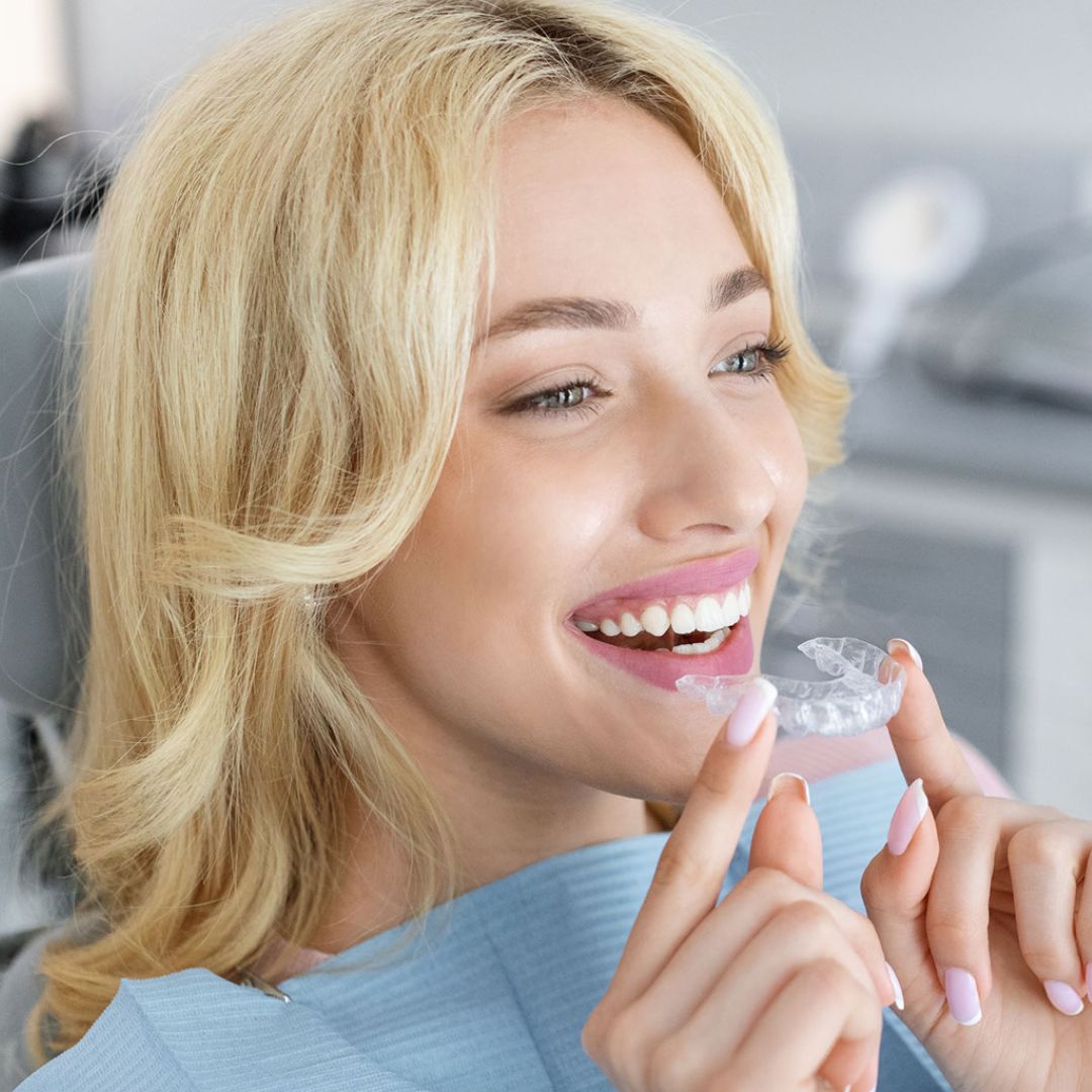 Woman smiling with Invisalign aligner